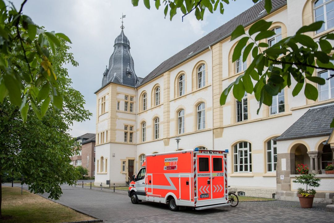 Krankenwagen hält vor Eingang des Alexianer Krankenhauses in Köln