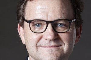 Prof. Dr. Klaus Lieb (Mainz) Ein Mann mit schwarzer Brille, Hemd und Jackett lächelt in die Kamera