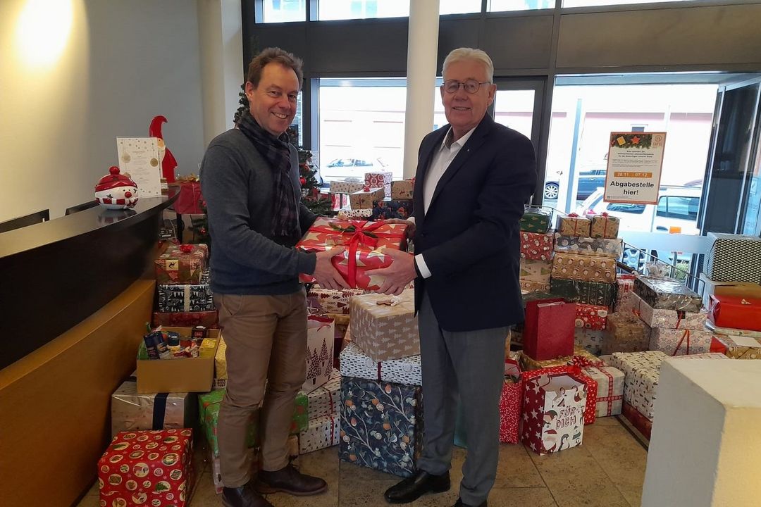 Der Leiter des Alexianer-Hotels "Begardenhof" Marc Roelofs übergibt die Geschenkpakete an Harald Augustin von der Kölner-Tafel-Stiftung
